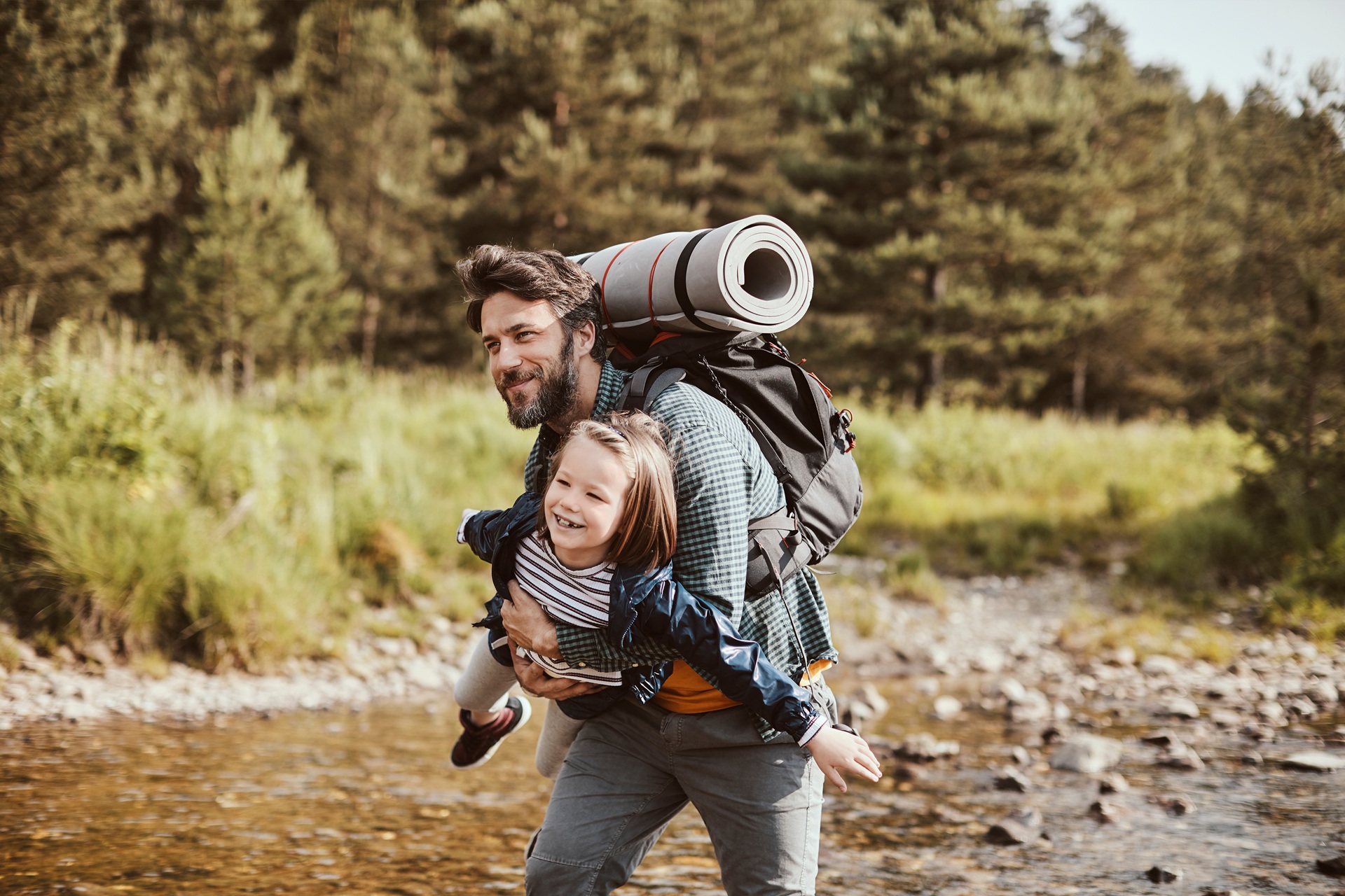 Vater trägt Kind am Fluss | Leuchtmunition