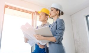 Architektin und Bauarbeiter prüfen Baupläne gemeinsam | modulares Bauen