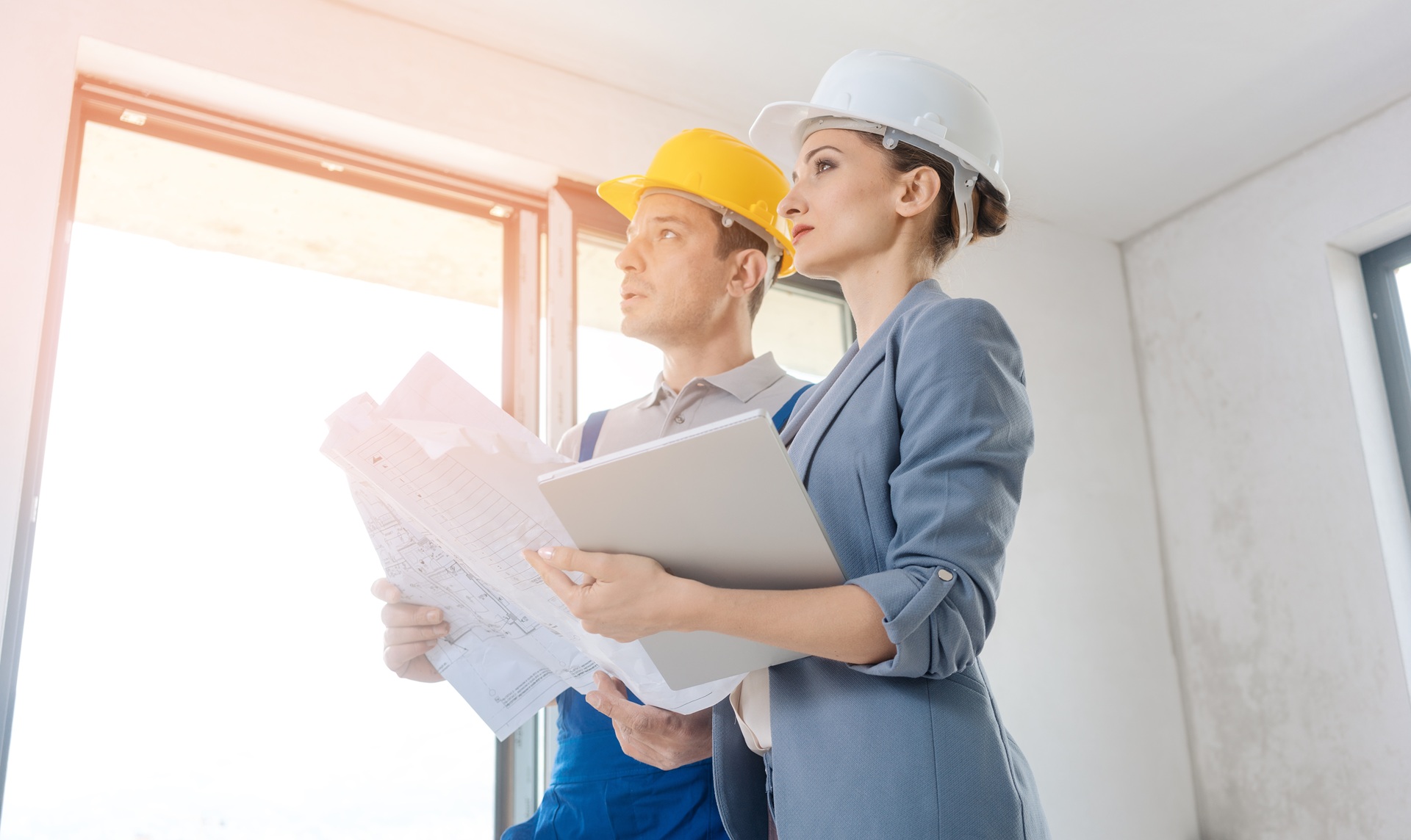 Architektin und Bauarbeiter prüfen Baupläne gemeinsam | modulares Bauen